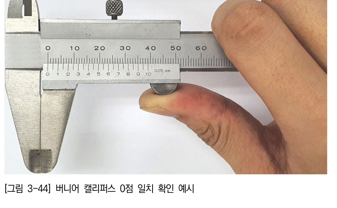 버니어캘리퍼스의 조를 닫아 0점과 측정면 빛 틈새를 확인하는 장면